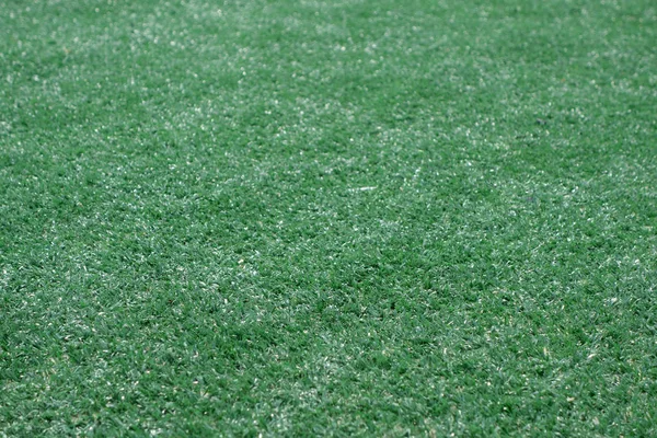 Kunstmatige groene kleur gras voetbalveld lening met vervaging. — Stockfoto