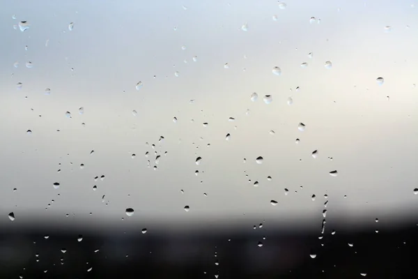 Chuva cai na janela com fundo azul . — Fotografia de Stock