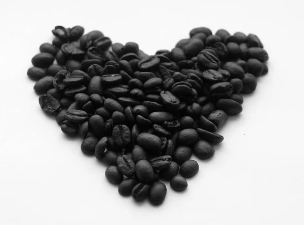 Chicchi di caffè a forma di cuore su bianco in bianco e nero . — Foto Stock