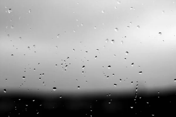 Dešťové kapky a rozostření pozadí oblohy v černé a bílé. — Stock fotografie