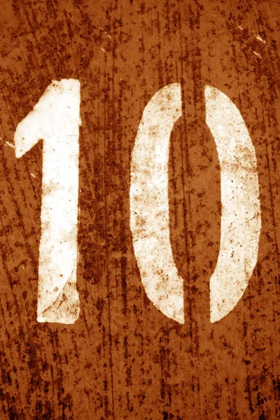 Número 10 em estêncil na parede de metal em tom laranja . — Fotografia de Stock