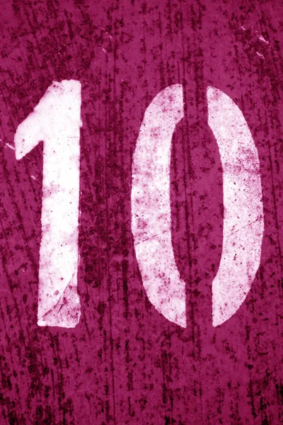 Número 10 en plantilla sobre pared metálica en tono rosa . —  Fotos de Stock