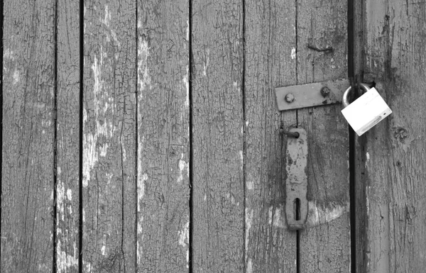 Old padlock on wooden gate in black and white. — Stock Photo, Image