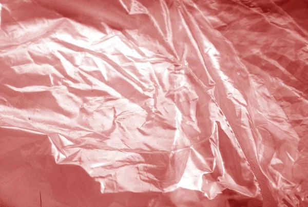 Plastic transparent old wrap texture in red tone.