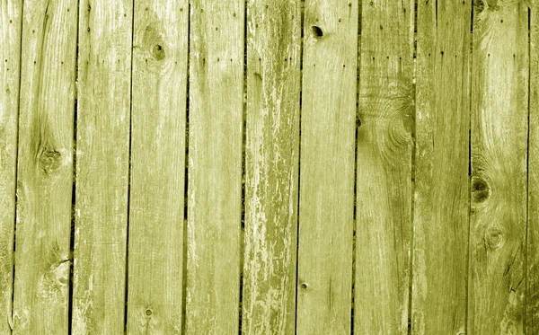 Weathered wooden fence in yellow color.