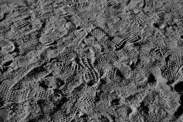 Muchas huellas en la arena en blanco y negro . — Foto de Stock