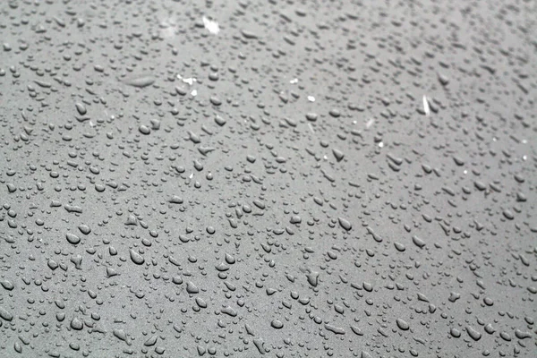 Gocce d'acqua sulla superficie dell'auto di colore grigio . — Foto Stock