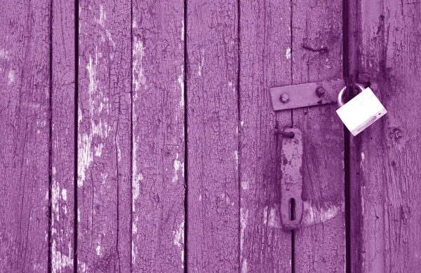 자줏빛 톤 의나무 문에 있는 낡은 자물쇠. — 스톡 사진