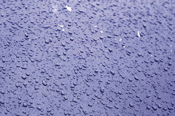 Vatten droppar på bil yta i blå ton. — Stockfoto