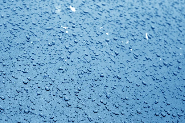 Gotas de agua en la superficie del coche en tono azul marino . — Foto de Stock