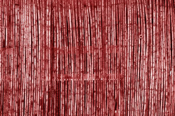 Cerca de bambu desgastado em tom vermelho . — Fotografia de Stock