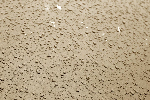 Wassertropfen in braunem Ton auf Autooberfläche. — Stockfoto