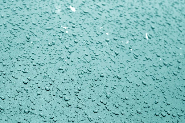 Gotas de agua en la superficie del coche en tono cian . — Foto de Stock