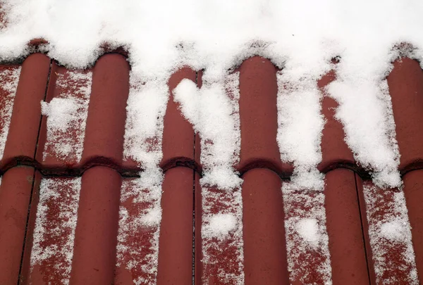 红色的平铺屋顶上的雪. — 图库照片
