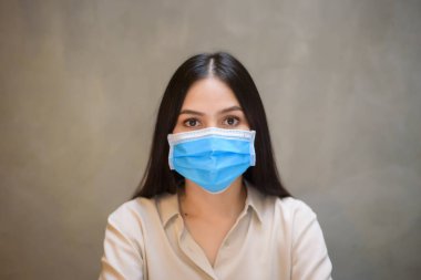 Maskeli güzel bir kadın kahve dükkanında bilgisayarla çalışıyor. 