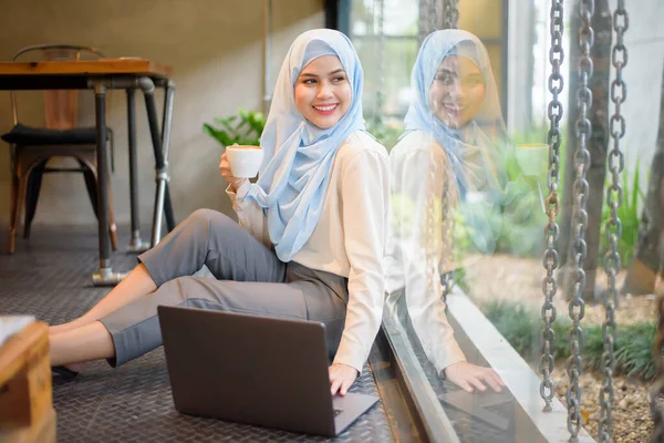 穆斯林妇女头戴头巾 在咖啡店用手提电脑工作 — 图库照片