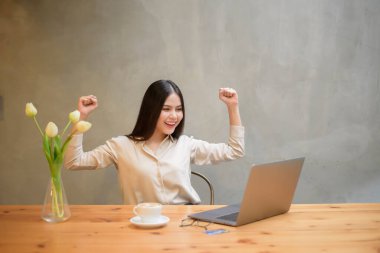 Güzel bir iş kadını kafeteryada dizüstü bilgisayarla çalışıyor.