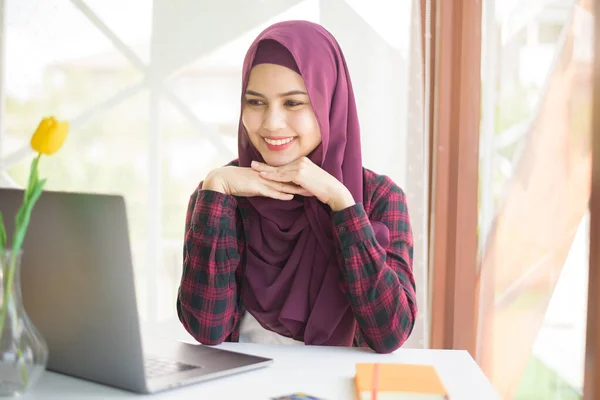 Muslim woman with hijab is working with laptop computer in coffee shop