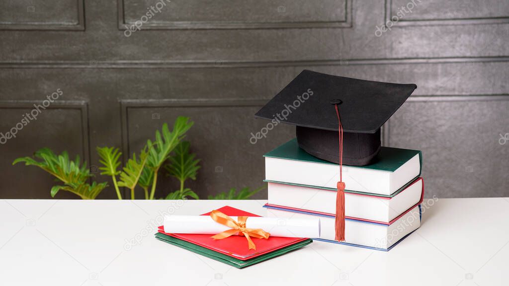 Graduation cap with books on white desk , Education background 