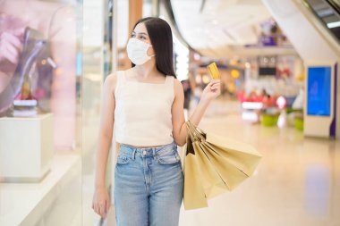 Güzel bir kadının portresi alışveriş merkezinde maske takıyor. 