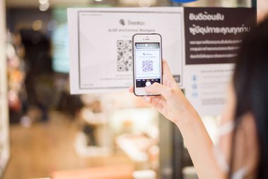 Bangkok, Tayland - Haziran 06, 2020: Alışveriş merkezinde COVID-19 önleme için Tayland 'ın Thaichana kampanyası ile insanlar akıllı telefon kullanıyor 