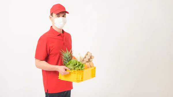 一名身穿红色制服 戴口罩的男子的画像是用白色背景的塑料盒盛放新鲜食品 — 图库照片