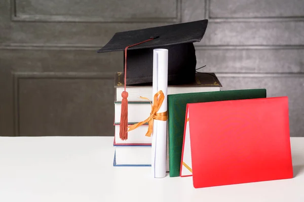 白书桌上有书的毕业帽 教育背景 — 图库照片