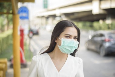 Otobüs durağında güzel bir kadın maske takıyor. 