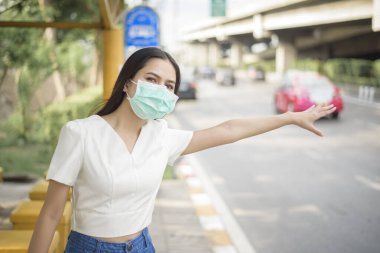 Otobüs durağında güzel bir kadın maske takıyor. 