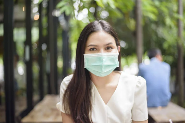 Beautiful woman is wearing face mask in coffee shop