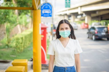 Otobüs durağında güzel bir kadın maske takıyor. 