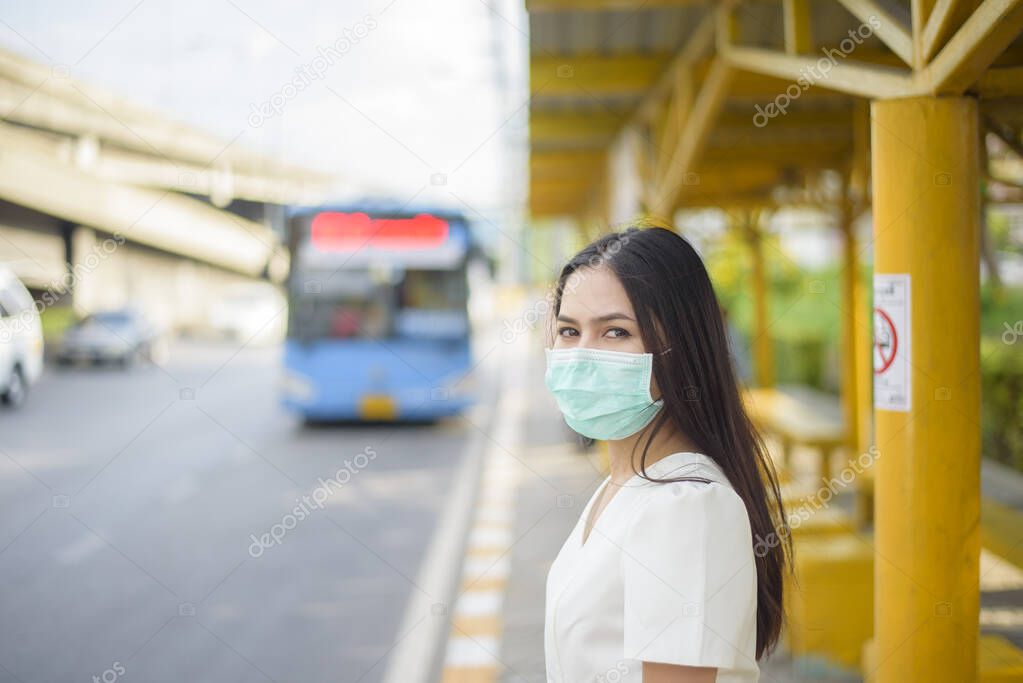 Beautiful woman is wearing face mask in bus stop 