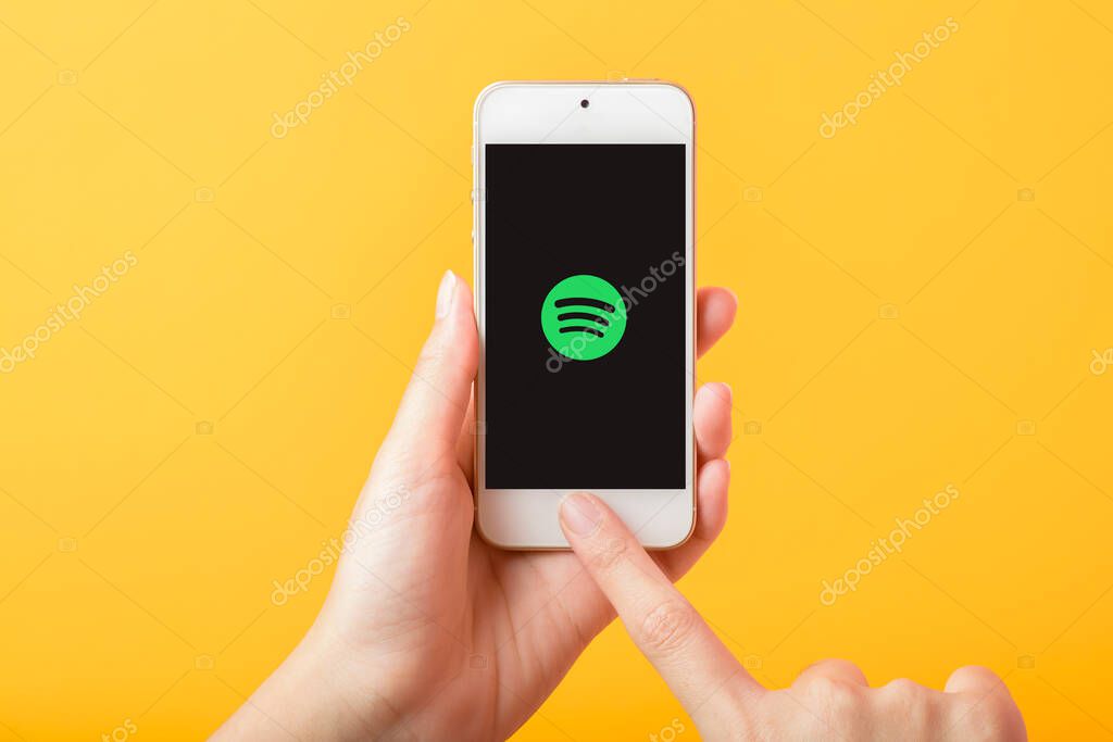 Bangkok, THAILAND, June 3, 2020: Woman hand holding Smart Phone with spotify logo on Apple iPhone SE