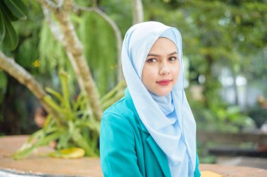 Başörtüsü olan Müslüman kadın kahve dükkanında dizüstü bilgisayarla çalışıyor.