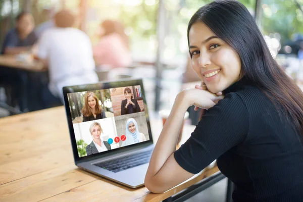Genç Kadın video konferans uygulaması aracılığıyla iş görüşmesi yaparken bilgisayar ekranına bakıyor