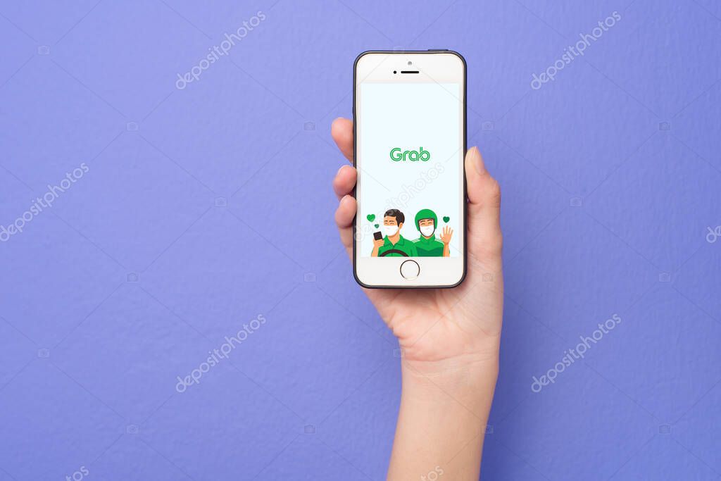 Bangkok, THAILAND, June 16, 2020: Woman hand holding Smart Phone with Grab logo on Apple iPhone SE