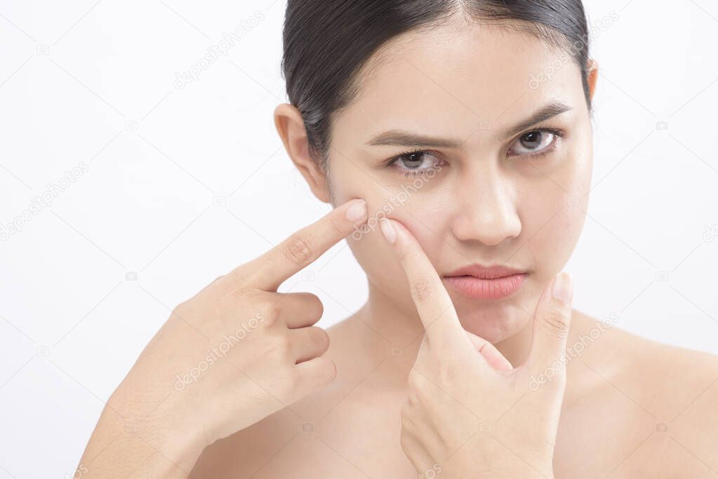 portrait of young beautiful woman is checking her skin and popping pimple over white background studio