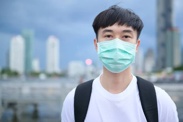 若いアジアの観光客の男は 外に立って保護マスクを着ている コロナウイルス保護 新しい通常の旅行の概念 — ストック写真