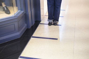 Kapalı kadın bacakları alışveriş merkezinde sosyal uzaklık çizgisinde duruyor. Yeni normal, sosyal uzaklık, covid-19 önleme konsepti.. 