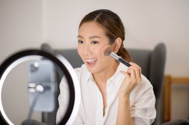 Güzel bir Asyalı makyaj blogcusu canlı yayında evinde güzellik, güzellik ve teknoloji konseptini nasıl düzelteceğini anlatıyor. . 