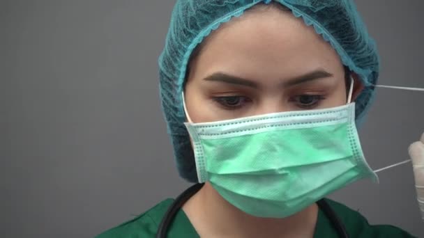 Портрет молодой женщины-врача в форме зеленых халатов, чувствующей себя подавленной и очень уставшей от пандемии ковид-19 — стоковое видео