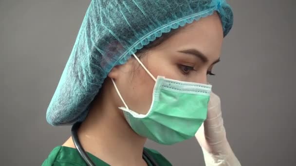 Πορτρέτο της νεαρής γυναίκας γιατρός με στολή πράσινο τρίβει αισθάνεται κάτω και πολύ κουρασμένος με πανδημία covid-19 — Αρχείο Βίντεο