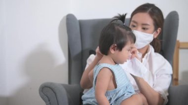 Anne ve kızı, Coronavirüs enfeksiyonundan korunmak için koruyucu maske takıyor, evde güvenlik, covid-19 koruma, ev kavramında sağlıklı.