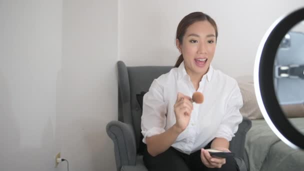 一位美丽的亚洲化妆品博客正在直播如何在家里面对化妆品 — 图库视频影像