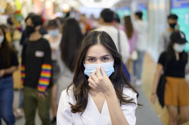 Bir kadın sokakta kalabalık insanlarla koruyucu maske takarken, covid-19 pandemisi, Coronavirus koruması, güvenlik yaşam tarzı konsepti.