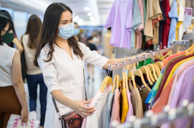 Yüzü maskeli kadın alışveriş merkezinde alışveriş yapıyor. Maskeli kadın alışveriş merkezinde alışveriş yapıyor. .