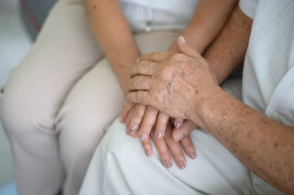 Close up of elderly hands holding each other , Grandfather hands is holding grandma hands , together , family concept .