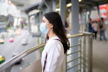 Sokak şehrinde yüz maskesi takan genç bir kadın, Coronavirus koruması, salgın altında yaşam tarzı, sağlık konsepti.