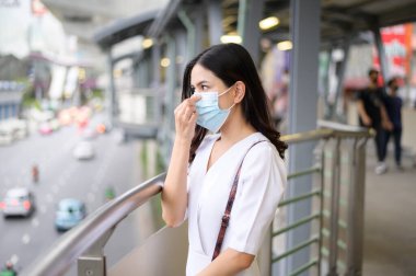 Sokak şehrinde yüz maskesi takan genç bir kadın, Coronavirus koruması, salgın altında yaşam tarzı, sağlık konsepti.