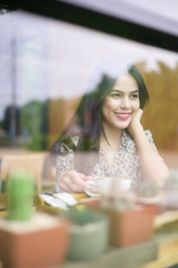 Genç ve güzel bir kadın kahvecide çalışıyor. . 